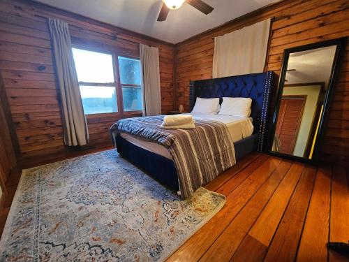 a bedroom with a bed in a room with wooden walls at Modern Log House First Level Primary in Winchester