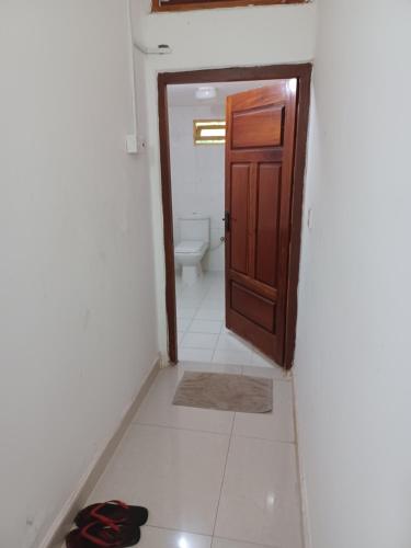a bathroom with a door and a toilet in it at Allens home stay in Jaffna