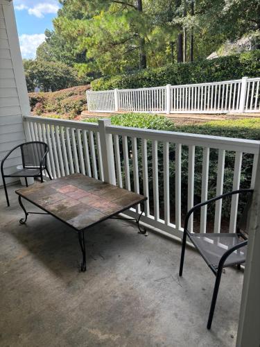 two chairs and a wooden table on a porch at Quaint one bedroom flat in Atlanta