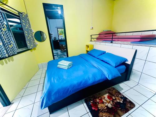 a bedroom with a bed with blue sheets and a mirror at AmanLo by Aman Homestay in Ranau