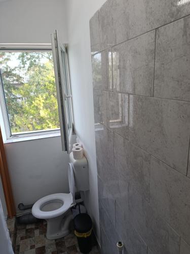 a bathroom with a toilet and a window at Max Night Dreams in Bucharest