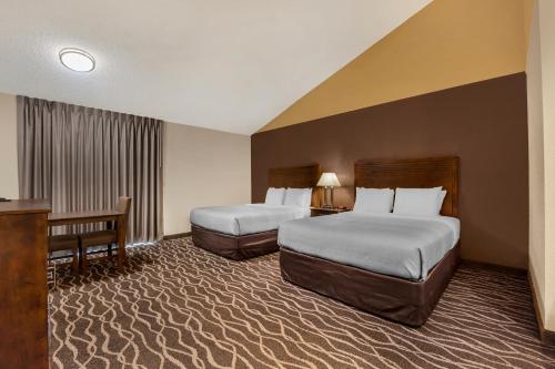 a hotel room with two beds and a desk at Quality Inn Umatilla - Hermiston in Umatilla