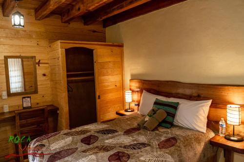 a bedroom with a bed and two lamps on tables at Roca Venados in Mascota