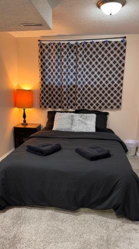 a bedroom with a black bed with two pillows at Calgary Super Cozy Guest Rooms Near Banff in Calgary