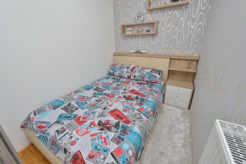 Dormitorio pequeño con cama con edredón en Apartment M, en Zadar