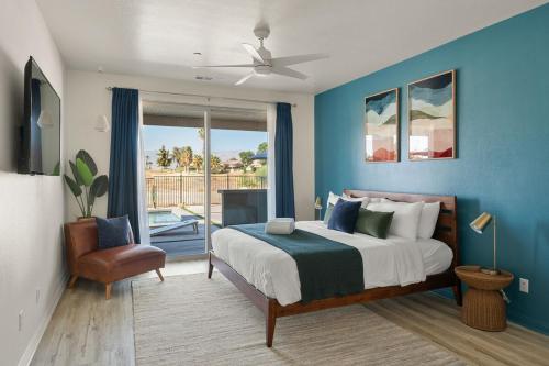 a bedroom with a bed with a blue wall at NEW Sunset Palms, AC Gameroom, Pool, Spa, EV charger in Indio