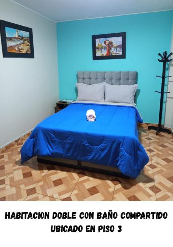 a bed in a room with a blue wall at Hostel AyJ Familia Round Trip Airport Tr4nsfer Included in Lima