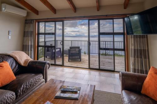 a living room with couches and a view of the ocean at Oreti Collection - By Vacations in Paradise in Turangi