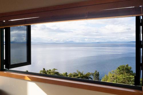 a window with a view of the water at Oreti Collection - By Vacations in Paradise in Turangi