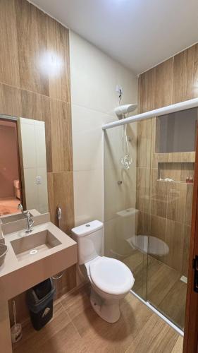 a bathroom with a toilet and a shower and a sink at Pousada Capivara Express in Baixas
