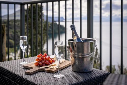 a table with wine glasses and a bucket on a balcony at Oreti Collection - By Vacations in Paradise in Turangi