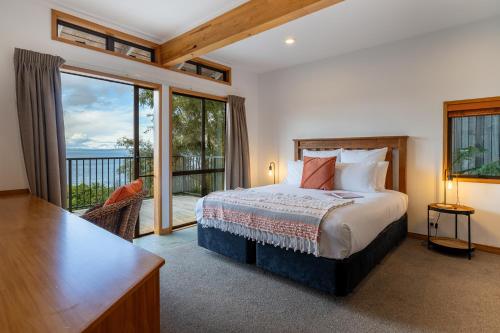 a bedroom with a bed and a large window at Oreti Collection - By Vacations in Paradise in Turangi