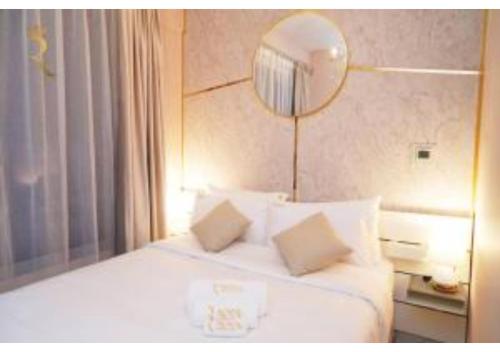 a hotel room with a white bed with a mirror at Jade Serenity 2BR - Pool, Gym & Comfort Near Masdar Park, Masdar City in Abu Dhabi