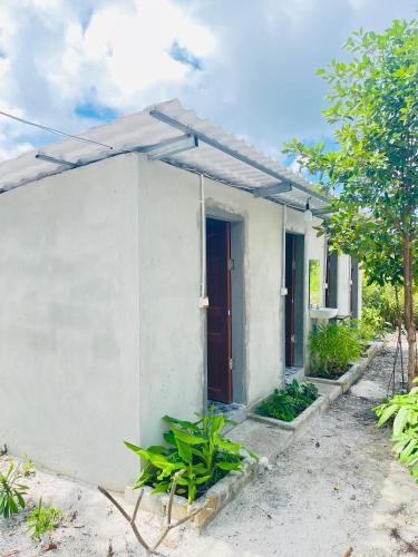 a small white house with a red door at Veha Koh Rong in Kaôh Rŭng