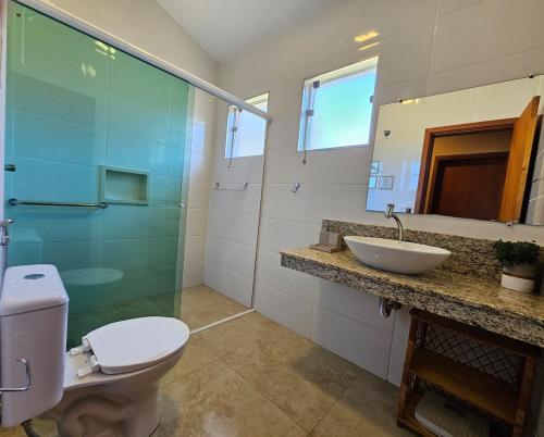 a bathroom with a toilet and a sink and a mirror at Piscina Aquecida Casa no Thermas de Sta Bárbara in Santa Bárbara do Rio Pardo