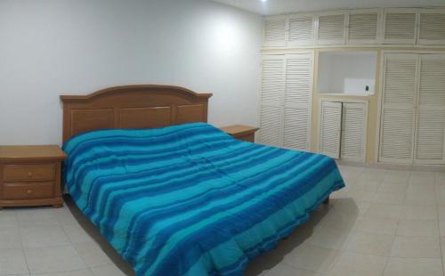 a bedroom with a bed with a blue blanket at Casa con aire acondicionado en habitación in Tuxtla Gutiérrez