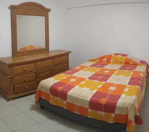 a bedroom with a bed and a dresser and a mirror at Casa con aire acondicionado en habitación in Tuxtla Gutiérrez