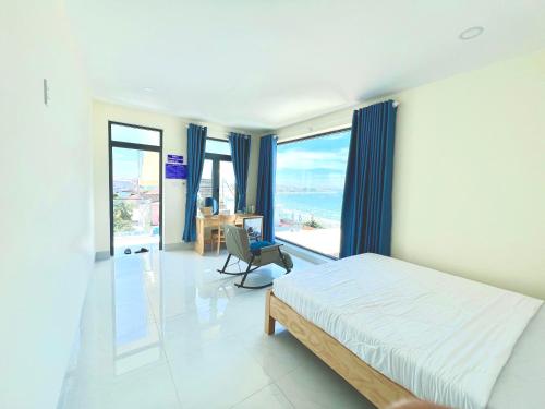 a bedroom with a bed and a desk and windows at Hoàng Hôn Nhớ Hotel in Ấp Khánh Phước (1)