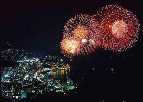 a fireworks display over a city at night at Private Fireworks View & Hot spring Villa Atami in Atami