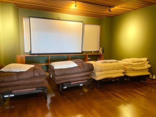 a room with several ottoman chairs and a projection screen at Private Fireworks View & Hot spring Villa Atami in Atami
