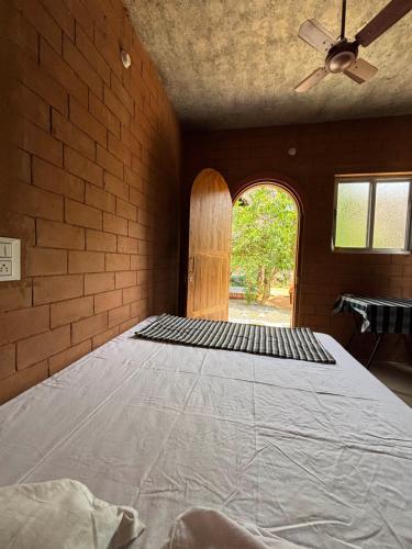 a large bed in a room with a ceiling fan at Time Travellers Hostel in Auroville