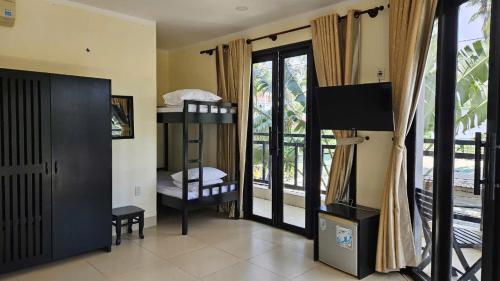 a room with a bedroom with a bunk bed and a balcony at Venus Mũi Né Resort in Mui Ne