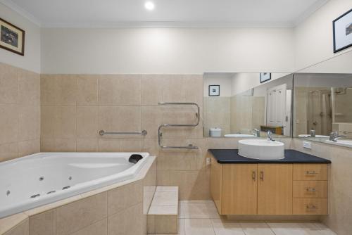 a large bathroom with a tub and a sink at Rhyll Seaside Penthouse in Rhyll