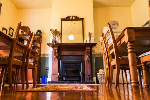 a living room with a fireplace and a table and chairs at Halfmoon Cottage in Akaroa