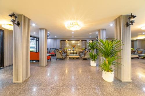 a lobby with couches and plants in a building at Xaysomboun Hotel & SPA in Vientiane