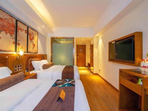 a hotel room with two beds and a flat screen tv at James Joyce Coffetel Kunming Railway Station Huancheng Nan Road Metro Station in Kunming