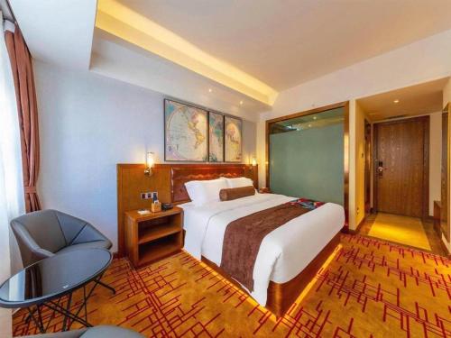 a hotel room with a bed and a desk and a chair at James Joyce Coffetel Kunming Railway Station Huancheng Nan Road Metro Station in Kunming