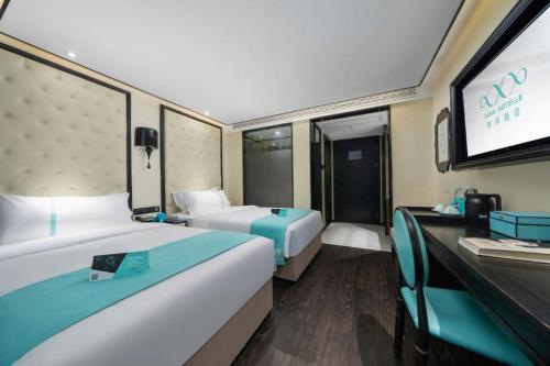 a hotel room with two beds and a flat screen tv at Xana Hotelle Shenzheng South Station Foxconn in Shenzhen