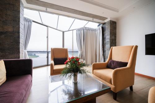 a living room with two chairs and a glass table at Baron Luxury Boutique in Nuwara Eliya