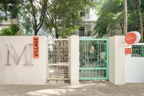 a gate in a white fence with a green door at M Village Living Trần Quốc Thảo in Ho Chi Minh City
