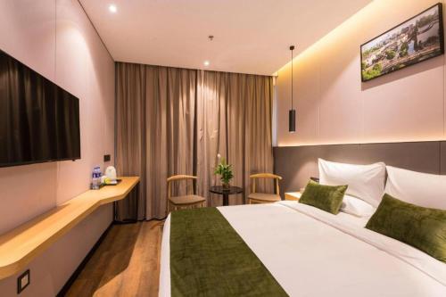 a hotel room with a bed and a desk at Green Tree Inn Express Fuzhou Three Lanes and Seven Alleys Nanmendou Metro Station in Fuzhou