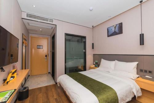 a bedroom with a large bed and a desk at Green Tree Inn Express Fuzhou Three Lanes and Seven Alleys Nanmendou Metro Station in Fuzhou