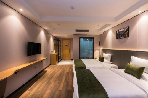 a hotel room with two beds and a television at Green Tree Inn Express Fuzhou Three Lanes and Seven Alleys Nanmendou Metro Station in Fuzhou