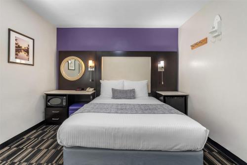 a hotel room with a large bed and a mirror at SureStay Hotel by Best Western Beverly Hills West LA in Los Angeles