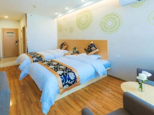 a hotel room with three beds in it at Green Tree Inn Fengxian New City Metro Station Jiukeshu Art Center in Shanghai