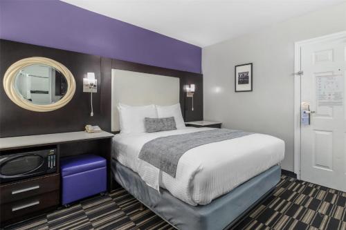 a bedroom with a large bed and a mirror at SureStay Hotel by Best Western Beverly Hills West LA in Los Angeles