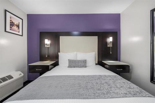 a bedroom with a large bed with purple walls at SureStay Hotel by Best Western Beverly Hills West LA in Los Angeles