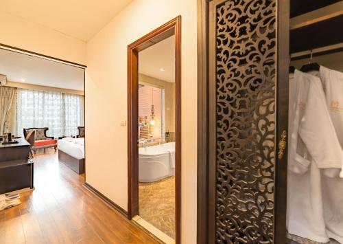a room with a mirror and a bathroom at Xaysomboun Hotel & SPA in Vientiane