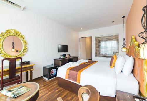 a hotel room with a bed and a table at Xaysomboun Hotel & SPA in Vientiane