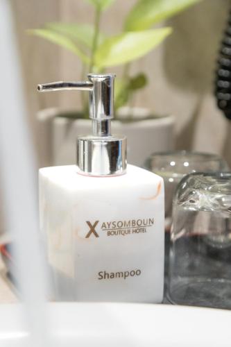 a white soap dispenser sitting on a bathroom counter at Xaysomboun Hotel & SPA in Vientiane