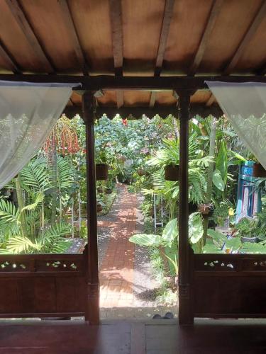 a view of a garden from the inside of a pavilion at Buratwangi Joglo House in Kerobokan