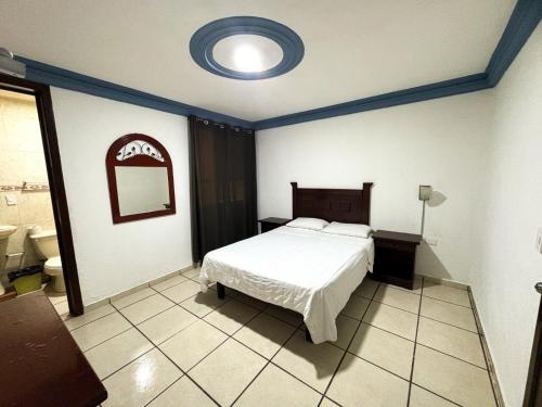 a bedroom with a bed and a mirror on the wall at Hotel paseo de la montaña in Silao