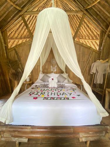a bed in a room with a canopy at Hidden Bamboo Village in Selat