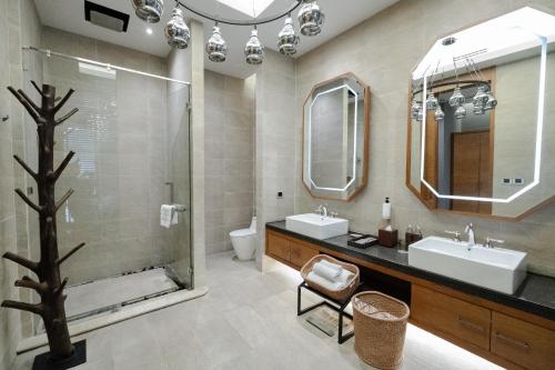 a bathroom with two sinks and a shower at The Gems Mining Pool Villas Pattaya in Nong Prue