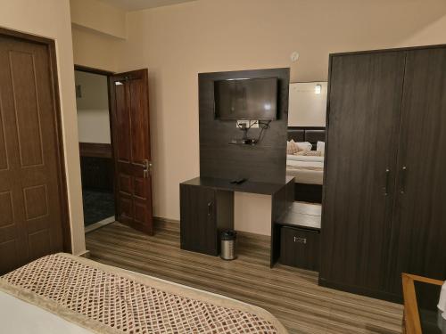a room with a bed and a tv and a bedroom at Hotel Shanti Palace in Gangtok
