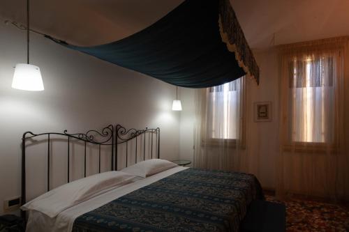 a bedroom with a bed and two windows at CityHotel Cristina Vicenza in Vicenza